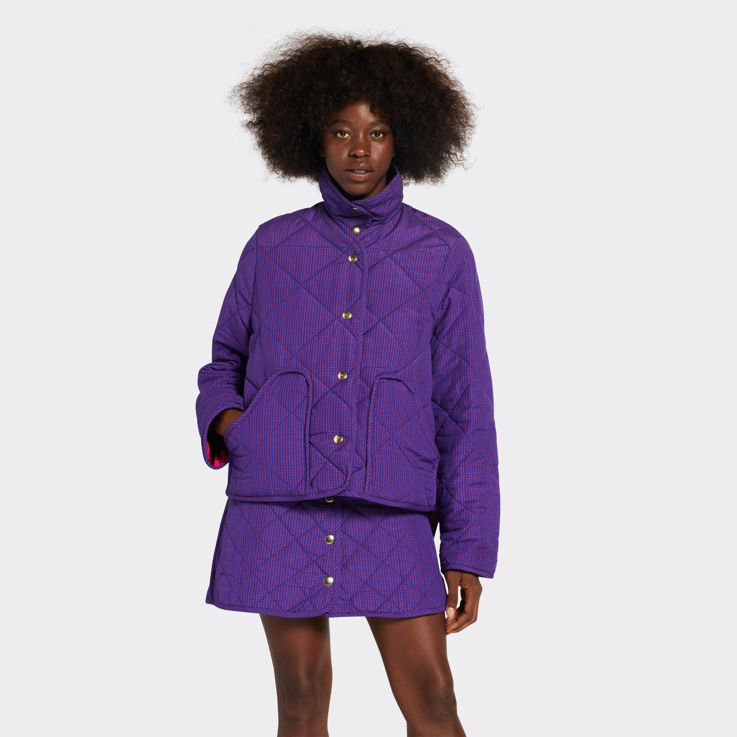 Reversible quilted jacket in pink checked Maasai fabric on model , on the purple side