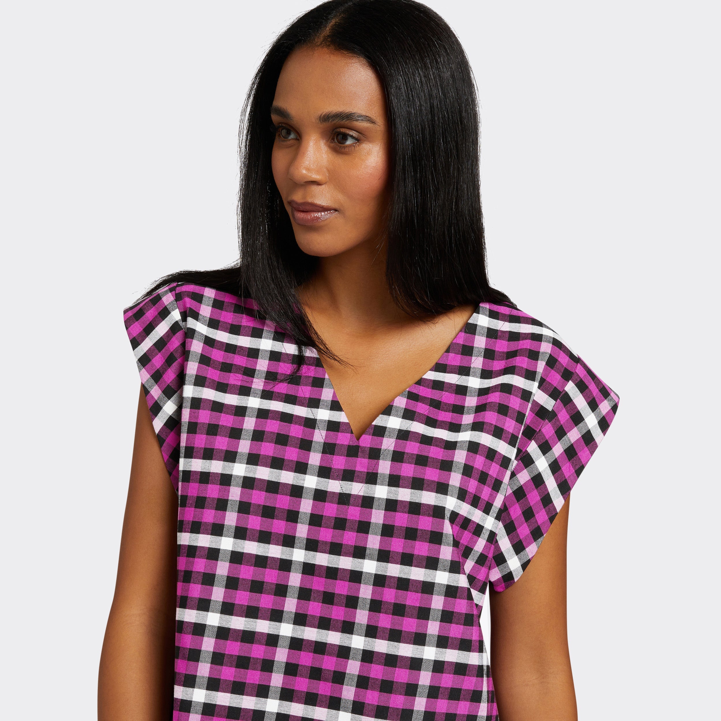 Model wears a V-Neck top with short sleeves. The print is Maasai Check in pink, black and white.