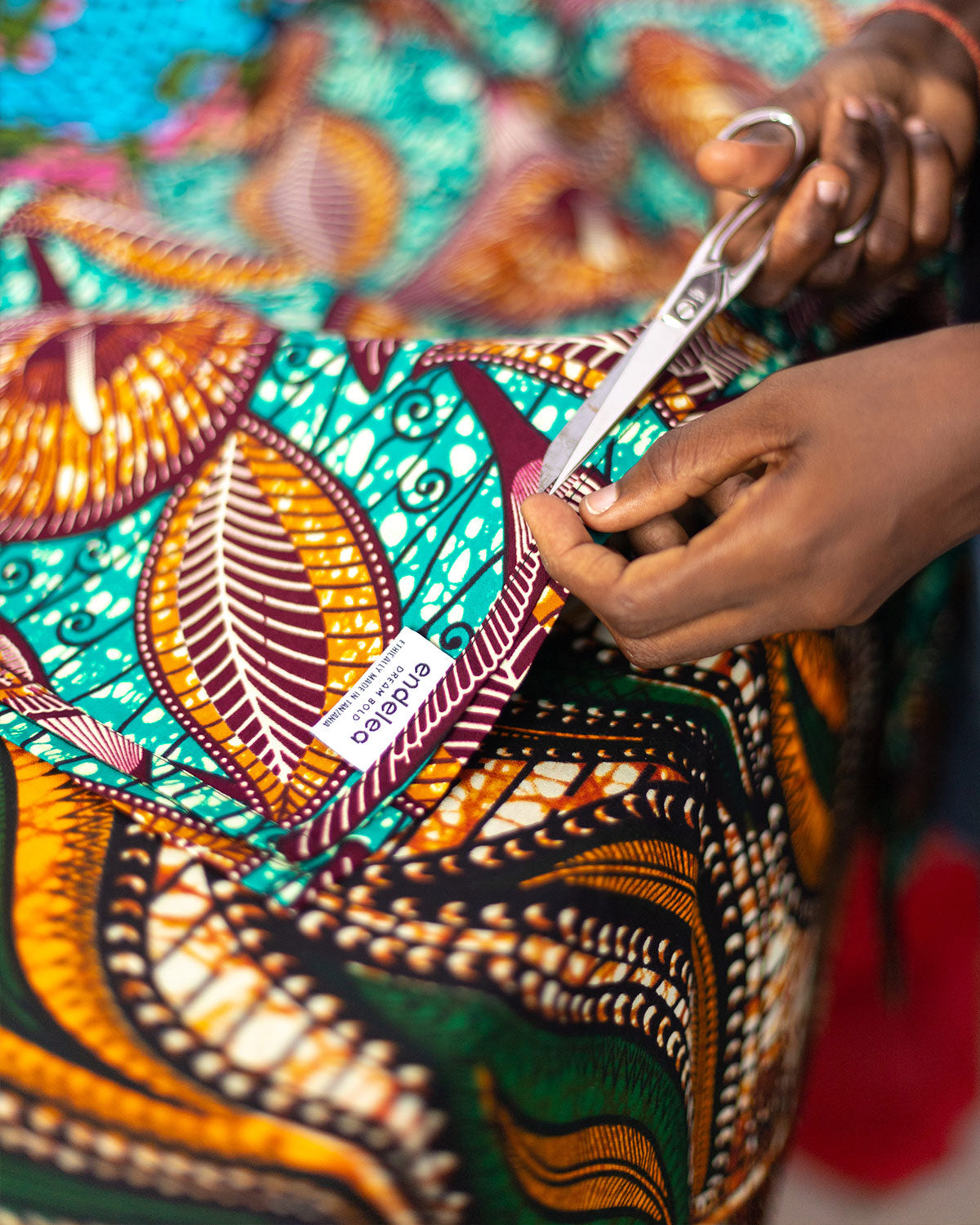 Taylor cutting a piece of wax fabric in Dar es Salaam