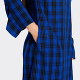 Detail of the pocket and ruffled sleeve of the Long blue dress in Maasai fabric with black checks on model