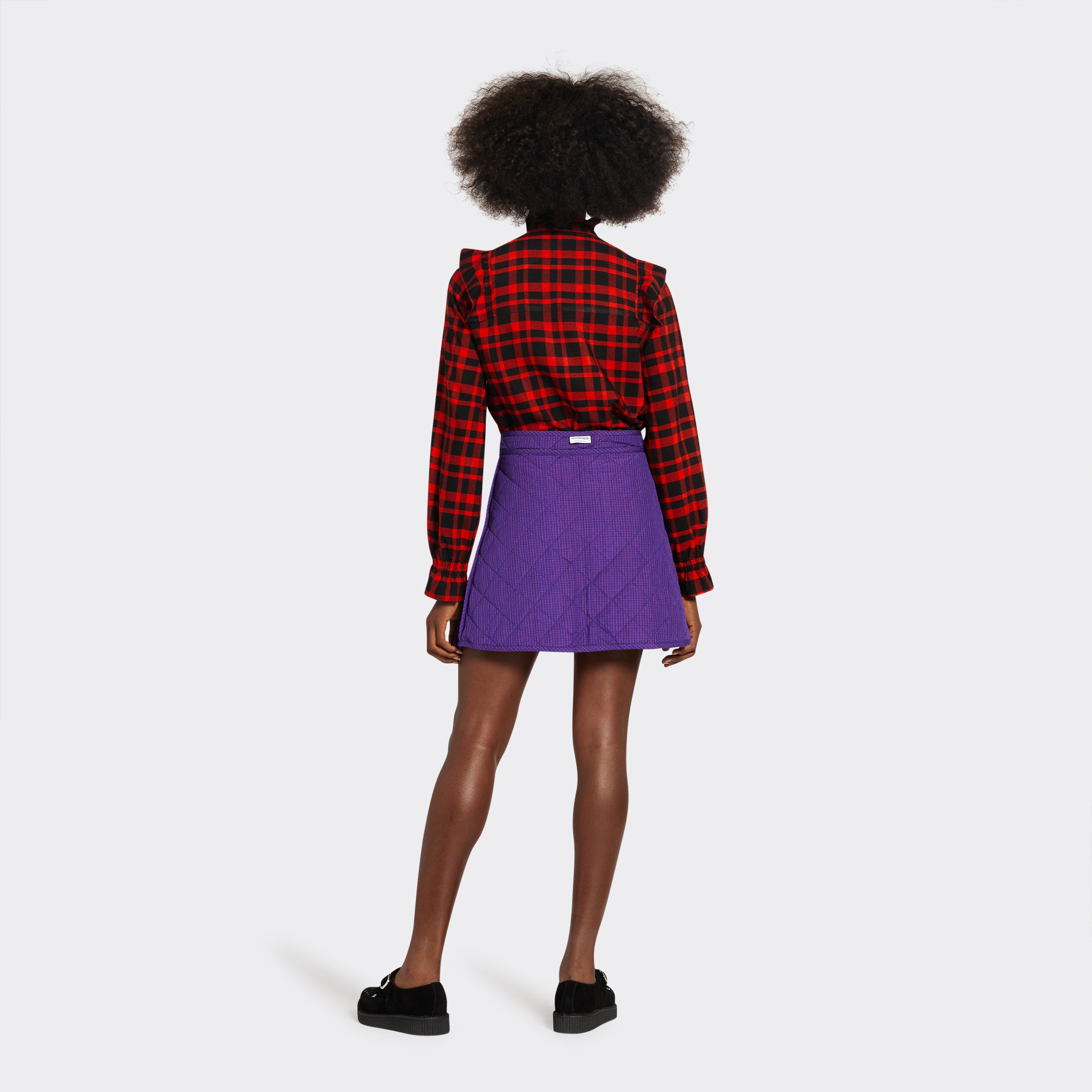 reversible padded miniskirt in maasai fabric worn on the purple side with micro checks