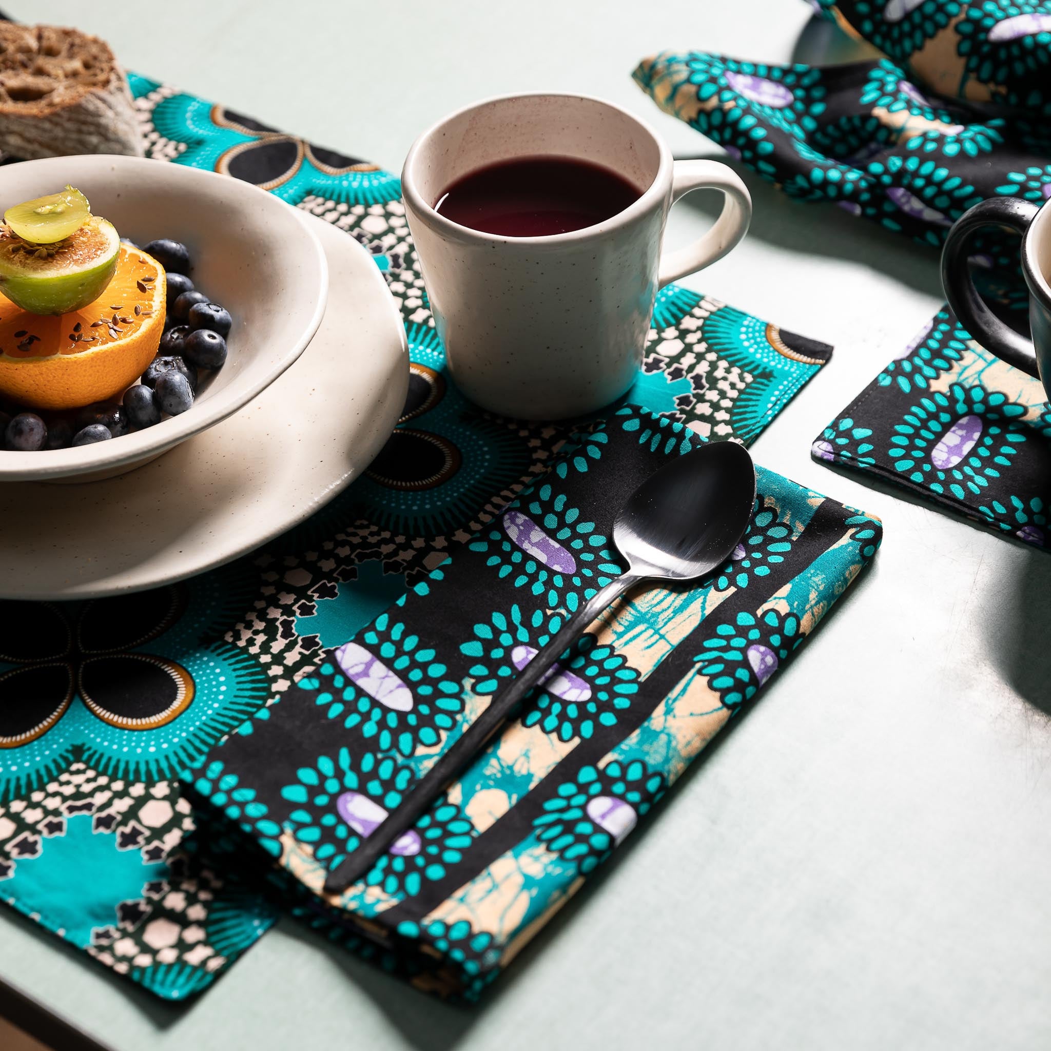 Napkins in wax fabric with matching placemat with a geometric print in black and green