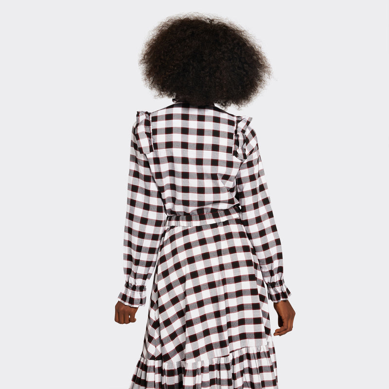 White shirt with ruffles on the front in maasai fabric with black checks on model seen from the back