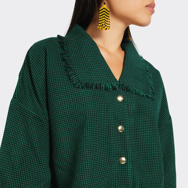 Detail of the collar of the green blouse with fringes in checkered Maasai Shuka fabric on model 