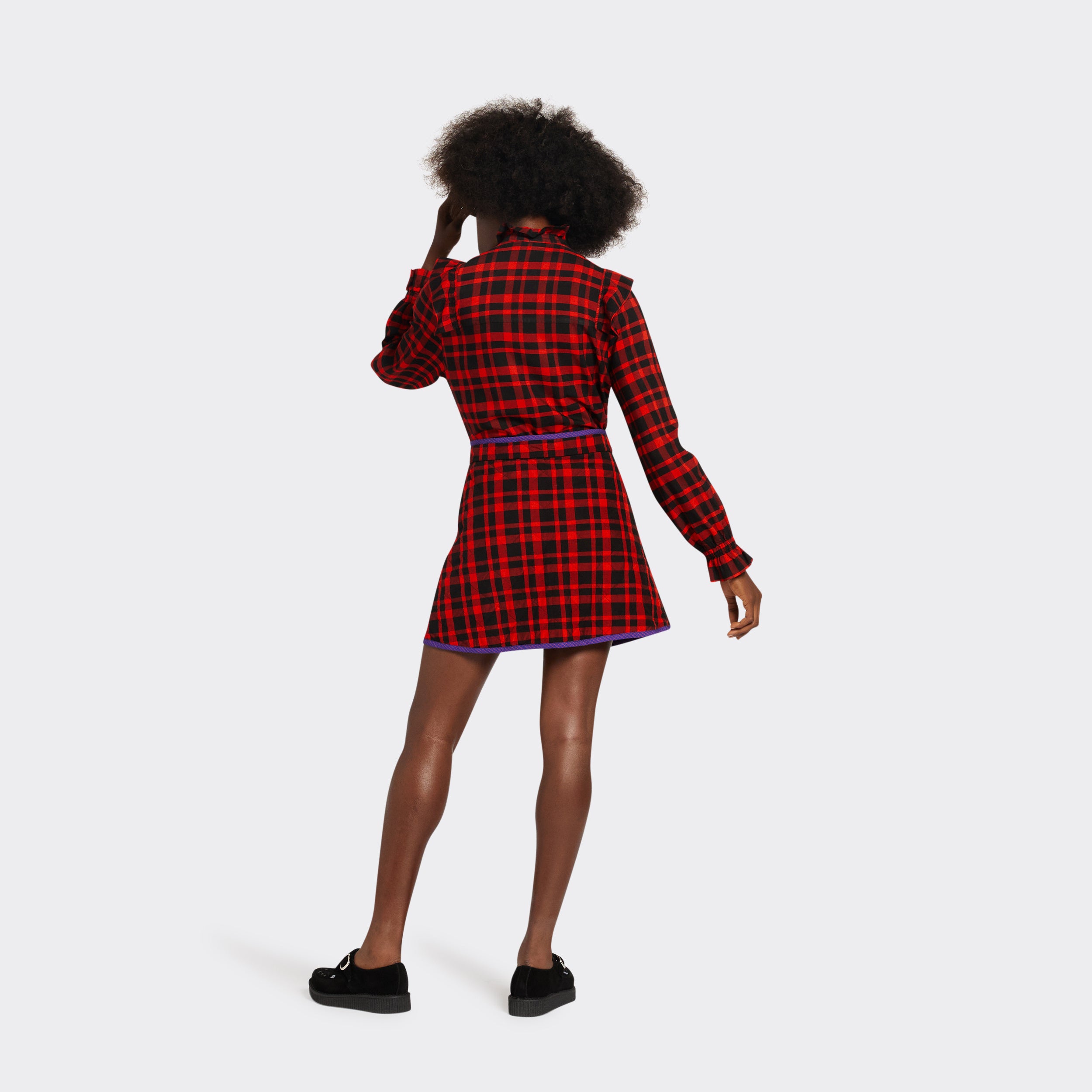 reversible padded miniskirt in maasai fabric worn on the black side with red checks seen from the back