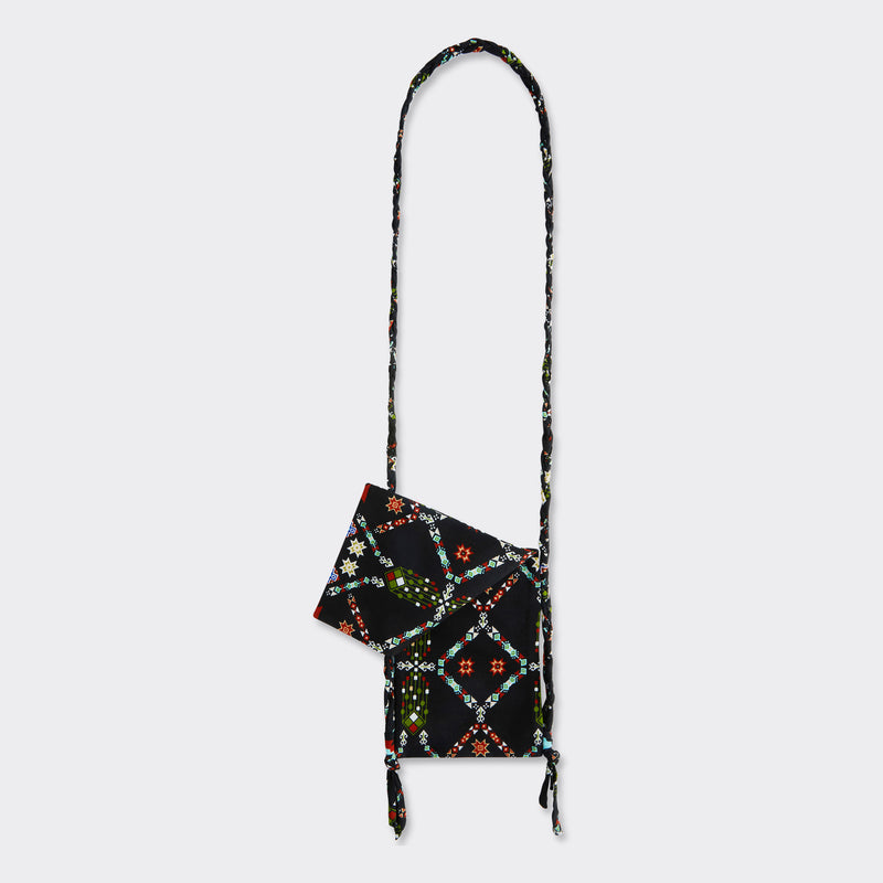 Still life: Crossbody Mini Bag in Wax Almasi Game with the colors black and red.