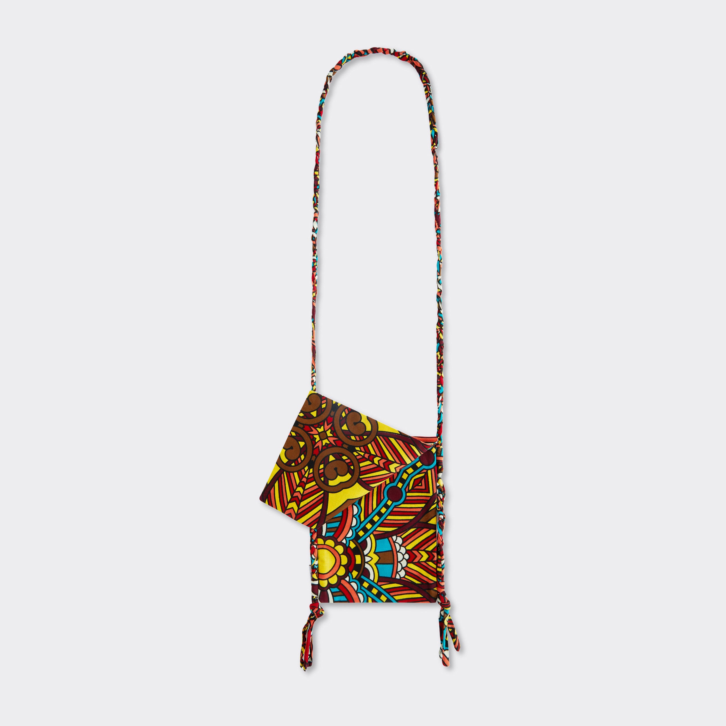 Still life: Crossbody Mini Bag in Wax African Dream with colors red, blue, and yellow.