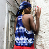Editorial photo: Model wears the Sleeveless Top in Tie Dye Soft Blue with a red skirt. She also wears a Pareo in Tie Dye Soft Blue on her head.