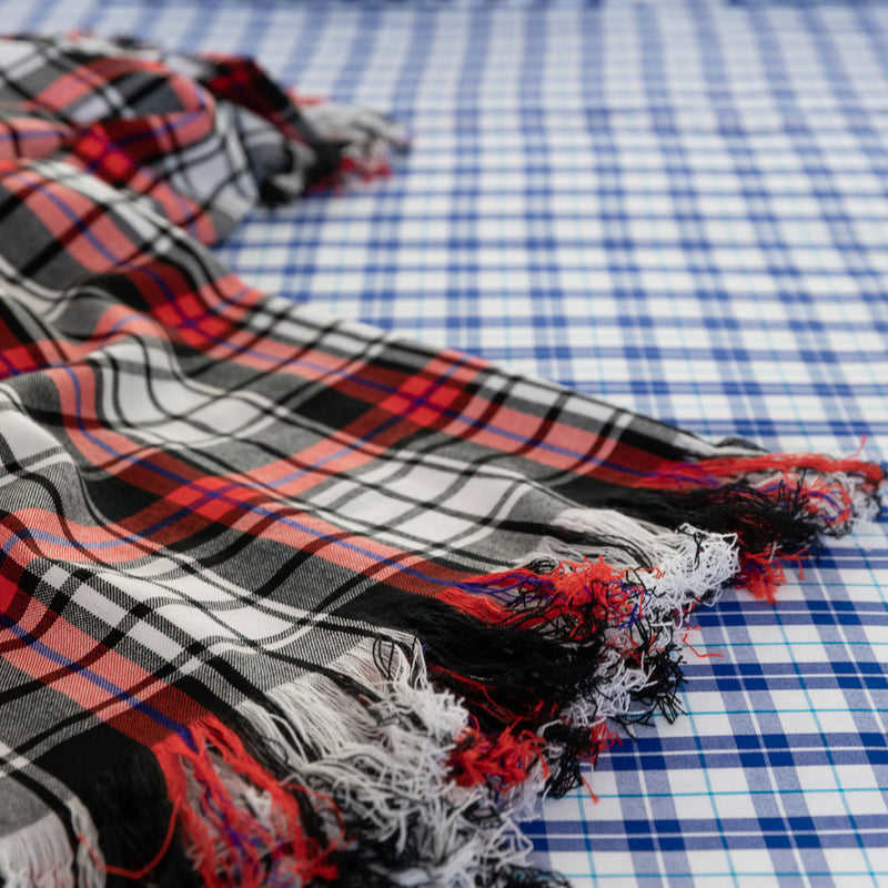 Details of checked blanket blacl, white and red in Maasai Shuka fabric above double bed