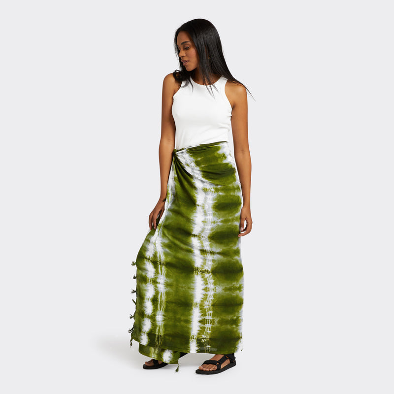 Model wears a Pareo in Tie Dye Intense Green as a skirt with a white tank top.
