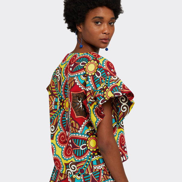 Model wears the Ruffled Top in Wax African Dream with the colors yellow, blue and red and she is wearing the the Flounced Maxi Skirt in Wax African Dream with the colors yellow, blue and red for a total look.