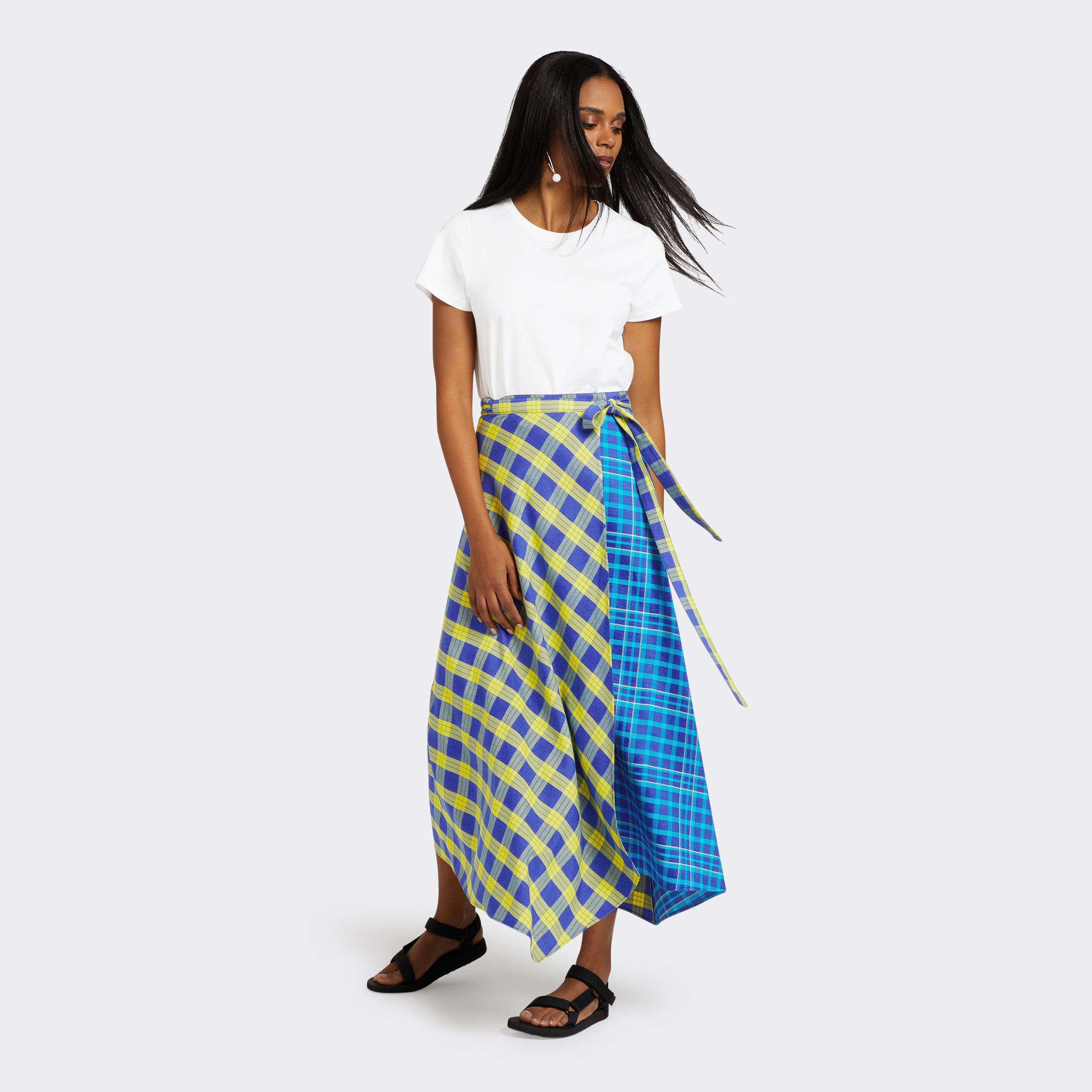 Model wears a Maasai Check wrap skirt in blue and yellow with a plain white tshirt.